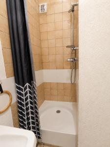 a shower with a black and white shower curtain at Studio cabine - proche plage - parking - wifi in Le Grau-du-Roi +14 photos