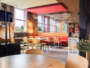 a dining room with tables and chairs in a restaurant at ibis Genève Aéroport in Geneva