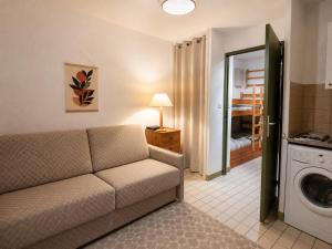 a living room with a couch and a washing machine at Studio cabine - proche plage - parking - wifi in Le Grau-du-Roi