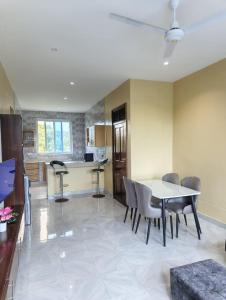 a kitchen and dining room with a table and chairs at Harlequin Diani in Diani Beach