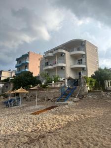 a building on the beach next to a beach at Magic Ionian Apartments & Rooms in Himare