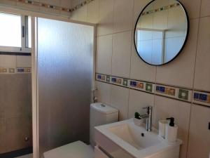 a bathroom with a toilet and a sink and a mirror at Dona Emília in Horta