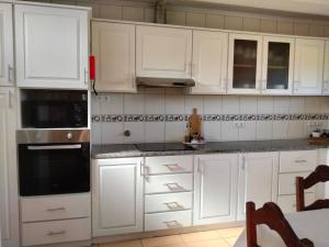 a white kitchen with white cabinets and appliances at Dona Emília in Horta +8 photos