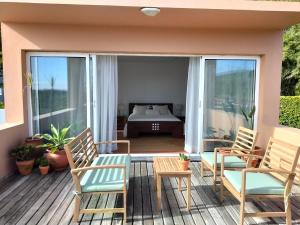 a patio with two chairs and a table on a deck at Dona Emília in Horta