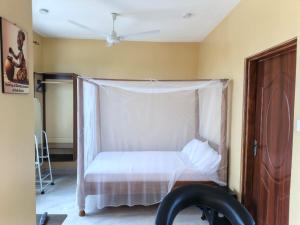 a bedroom with a bed with a mosquito net at Harlequin Diani in Diani Beach