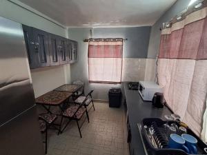 a small kitchen with a counter and chairs in it at Nic's Inn in Freetown