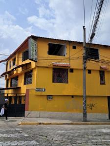 a yellow building on the side of a street at San Sebastian Hostal in Sangolquí