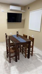 a dining room table with chairs and a tv at Departamento Los Ceibos 2 in San Fernando del Valle de Catamarca