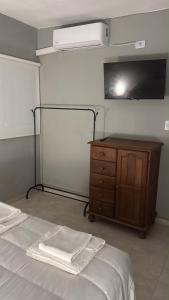 a bedroom with a bed and a dresser and a flat screen tv at Departamento Los Ceibos 2 in San Fernando del Valle de Catamarca