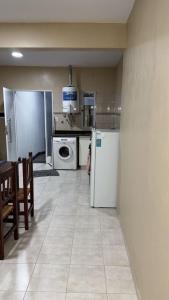 a kitchen with white appliances and a table and chairs at Departamento Los Ceibos 2 in San Fernando del Valle de Catamarca