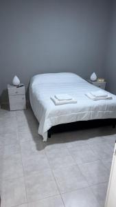 a bedroom with a large bed with a white bedspread at Departamento Los Ceibos 2 in San Fernando del Valle de Catamarca