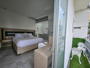 a bedroom with a bed and a sliding glass door at Hotel San Jeronimo Armenia in Armenia