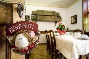 a dining room with a table with a doll in a chair at Bed & Breakfast Villa Chiara in Magenta