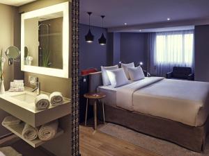 a hotel room with a large bed and a bathroom at Grand Mercure Brasilia Eixo Monumental in Brasília