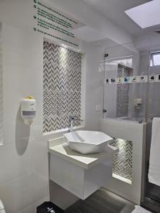 a white bathroom with a sink and a shower at Hotel San Jeronimo Armenia in Armenia
