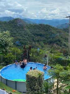 a group of people in a swimming pool with mountains in the background at FInCA LA BENDICIÓN DE SUNNYVALE in La Vega