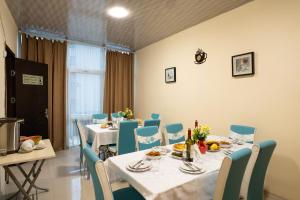 a dining room with a table and chairs with food at Chill Out Hotel Tskaltubo in Tsqaltubo