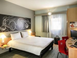a hotel room with a large bed and a desk at ibis Orange Sud in Orange