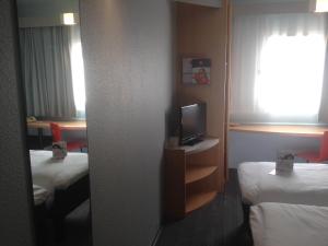 a hotel room with two beds and a television at ibis Orange Sud in Orange