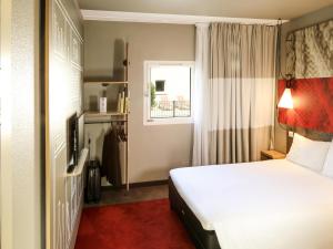 a hotel room with a bed and a window at ibis Orange Sud in Orange +85 photos