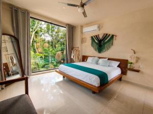 a bedroom with a bed and a large window at Yaakun in Bacalar