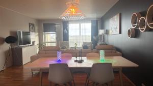 a living room with a table with chairs and a couch at Akranes Sunset Apartment in Akranes +29 photos