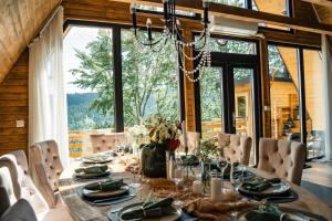 a dining room with a long table and a large window at Black Roof in Arada