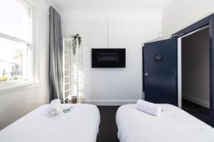 a hotel room with two beds and a tv at The Albion Hotel in Wickham