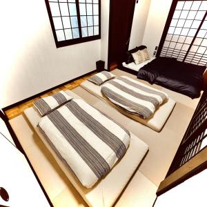two beds sitting on the floor in a room at Between Kyoto & Osaka 渚西 駅徒歩6分 in Hirakata