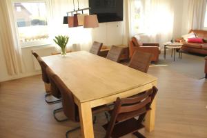 a wooden table and chairs in a living room at Ferienwohnung "Groote Koje" in Barßel