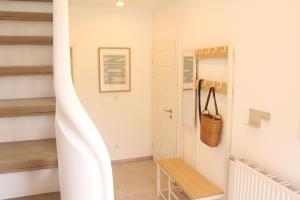 a hallway with stairs and a bench in a house at Ferienwohnung "Groote Koje" in Barßel