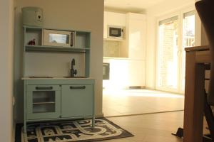 a kitchen with a blue cabinet in a room at Ferienwohnung "Groote Koje" in Barßel +9 photos
