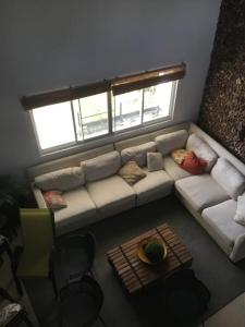a living room with a white couch and two windows at Casa Malibú Gorgona in Nueva Gorgona +3 photos