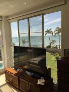 a living room with a flat screen tv in front of a window at Casa Malibú Gorgona in Nueva Gorgona