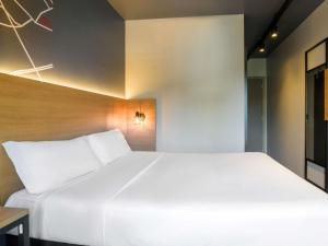 a bedroom with a large white bed and a desk at ibis Curitiba Batel in Curitiba +91 photos