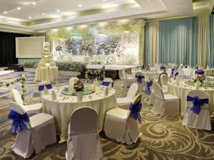 a banquet hall with white tables and white chairs at Mercure Convention Center Ancol in Jakarta +128 photos