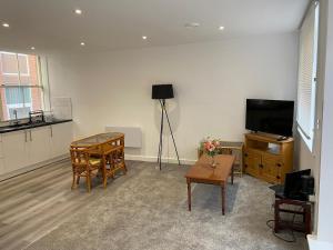 a living room with a television and a table at Have a fun and rest in Hull