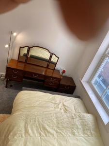 a bedroom with a bed and a dresser with a mirror at Have a fun and rest in Hull