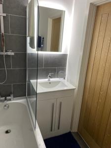a bathroom with a sink and a mirror and a shower at Have a fun and rest in Hull