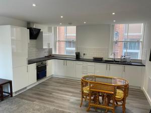 a kitchen with white cabinets and a table and chairs at Have a fun and rest in Hull