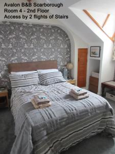 a bedroom with a bed with two towels on it at Avalon B&B Scarborough in Scarborough