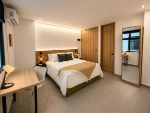 a hotel room with a bed and a desk and a desk at Once Suites in Envigado