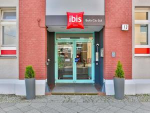 a door to a store with a sign on it at ibis Berlin City Süd in Berlin