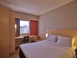 a hotel room with a large bed and a window at ibis Recife Boa Viagem in Recife