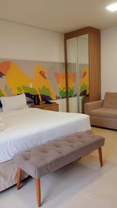 a bedroom with a bed and a couch at Apartamento Residence Ecoresort Capivari in Campina Grande do Sul +20 photos
