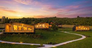 a house on a hill with a sunset in the background at Volcano Suites in Puyehue