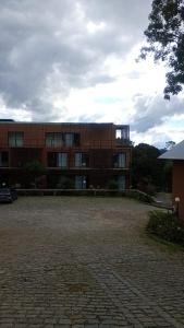 a building with a brick courtyard in front of it at Apartamento Residence Ecoresort Capivari in Campina Grande do Sul