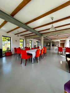 a dining room with a white table and red chairs at Siedlisko Kierzkowo in Kierzkowo
