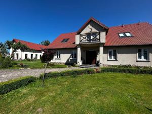 a house with a red roof and a yard at Siedlisko Kierzkowo in Kierzkowo