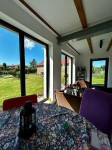 a dining room with a table and some windows at Siedlisko Kierzkowo in Kierzkowo